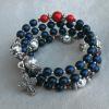 Navy blue Czech glass Aves with diamond-cut aluminum Paters and red accents.