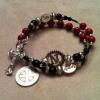 Red fossil riverstone; black Czech glass; pewter rondelles; sterling silver beads of "N," "Pray," and "Family"; and the client's own crucifix and St. Benedict medal